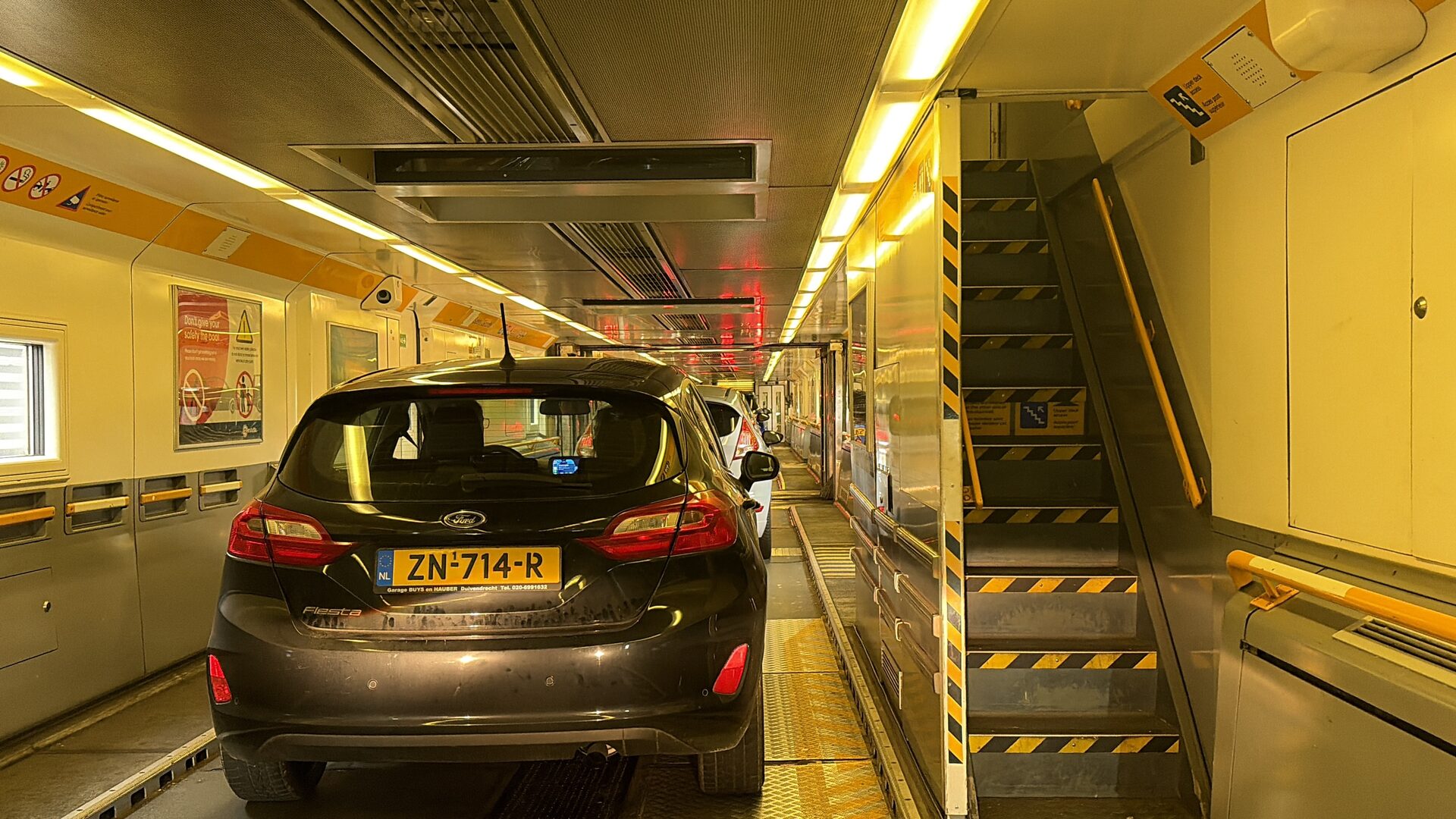 Inside a LeShuttle carriage with a car driving through the connecting doors