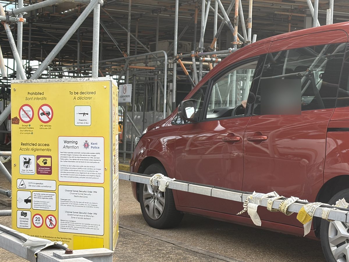 Customs sign listing prohibited and declarable goods beside a car in a Folkestone check-in lane
