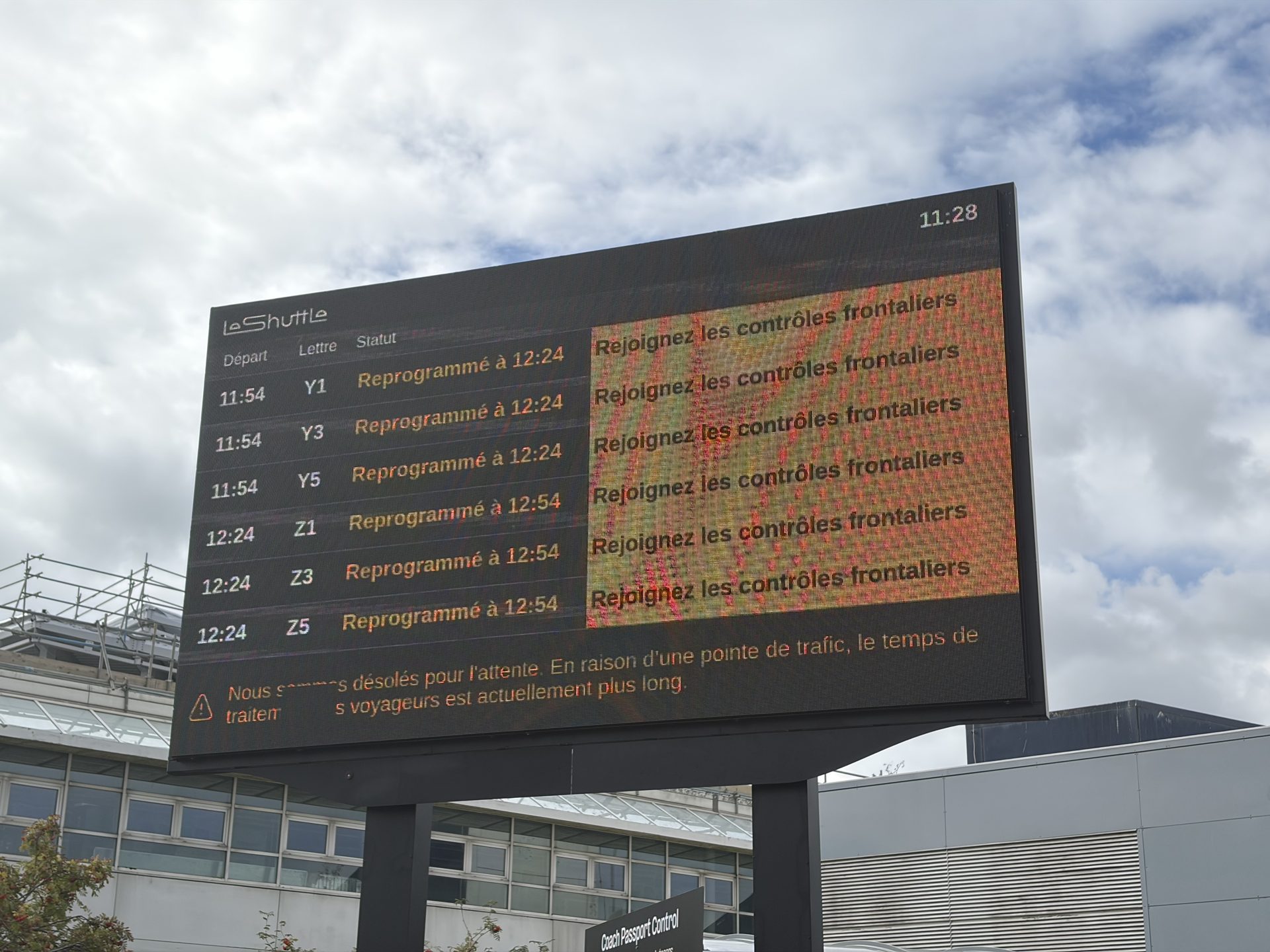 Digital departure board at the Folkestone terminal showing rescheduled departure times