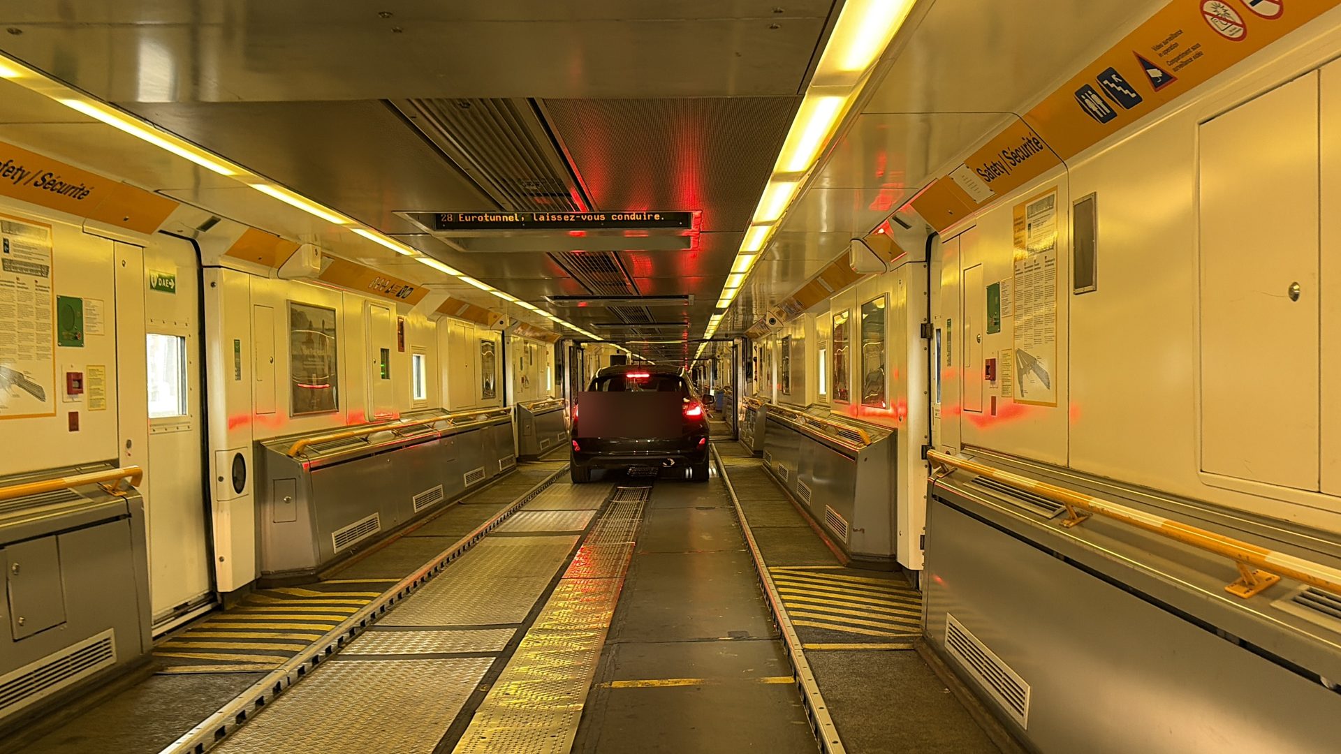 Inside a LeShuttle carriage with a car driving through the connecting doors